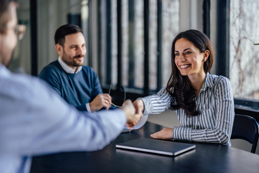 women smiling to her client and shaking hands
